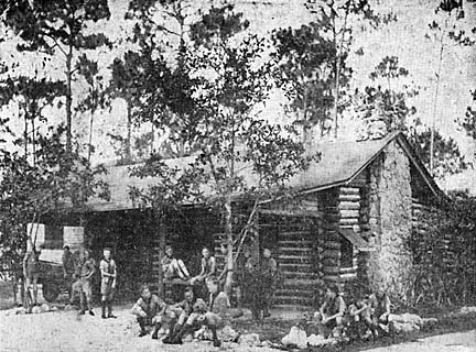 Scouts around front of cabin
