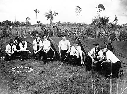 Patrol campsite with boys kneeling in front of tents